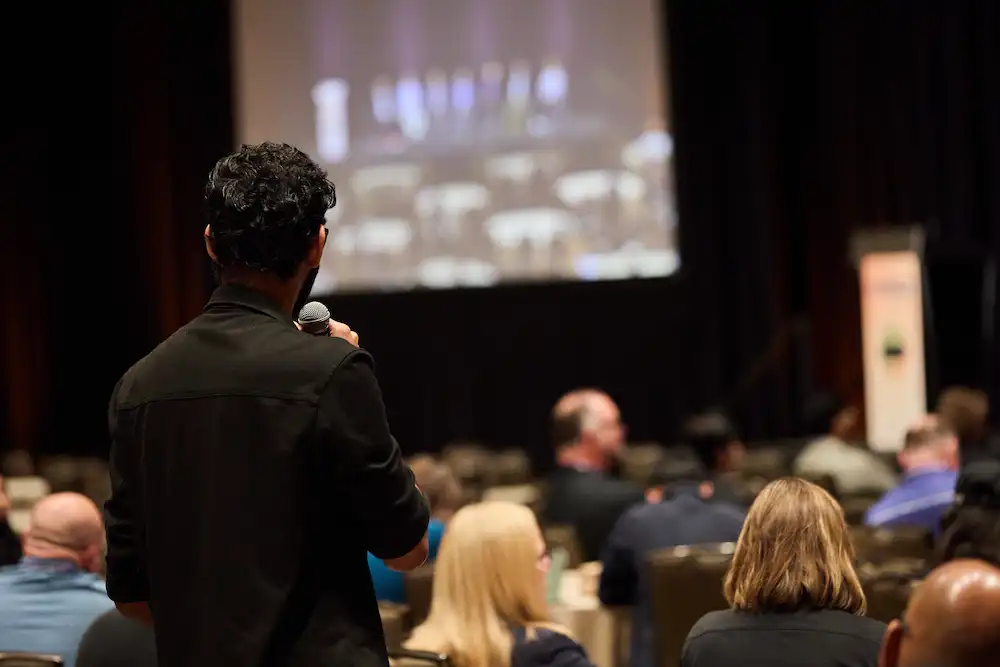 An attendee asks a question during a 2025 summit session