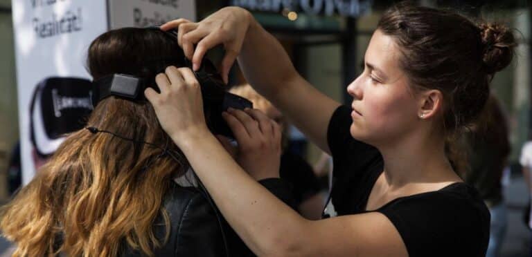 An image of a hairstylist working on a customer's hair, using styling tools and focusing intently on the task.