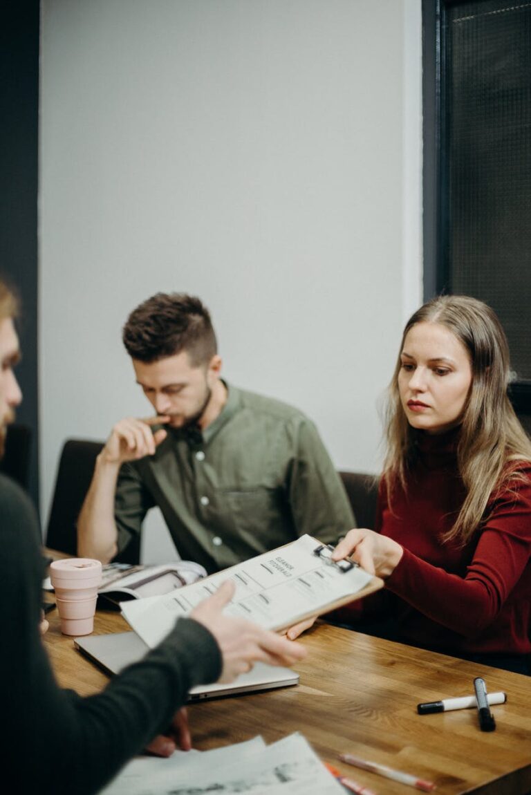 Two people working together on a project, a man and a woman reviewing documents on a table