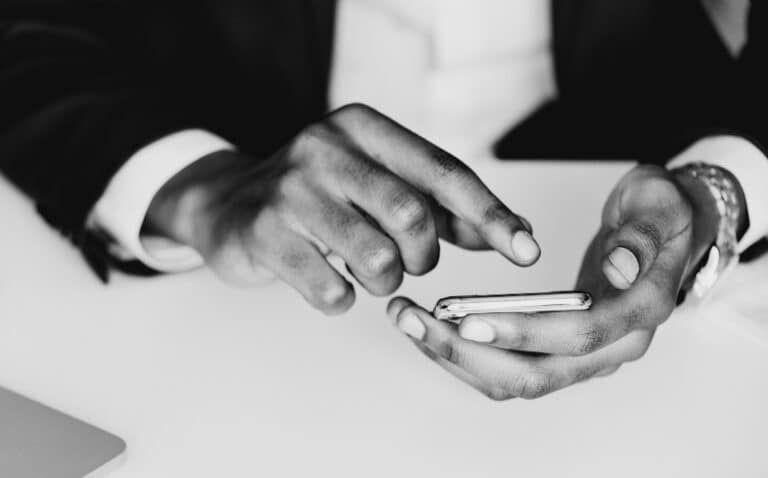 Close-up of a person's hands holding a smartphone in a business setting