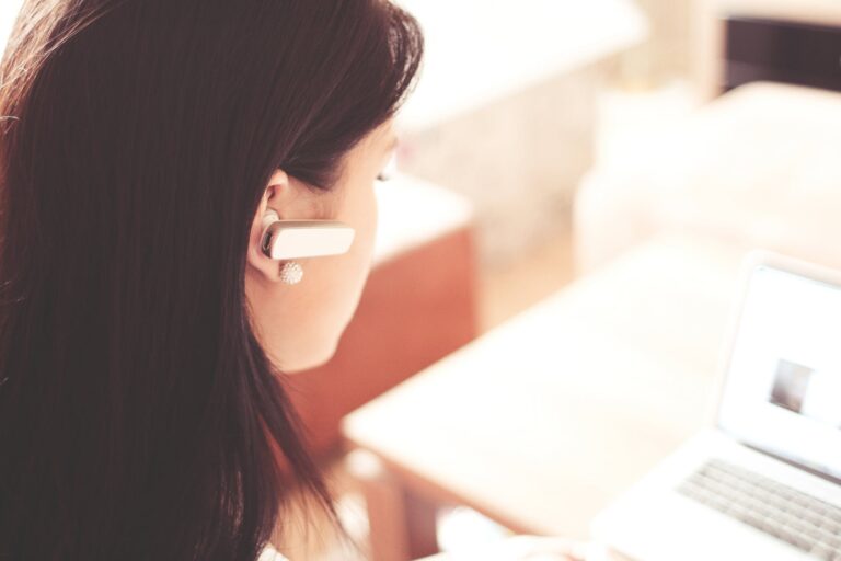 Close-up side view of a woman with long dark hair talking on a mobile phone
