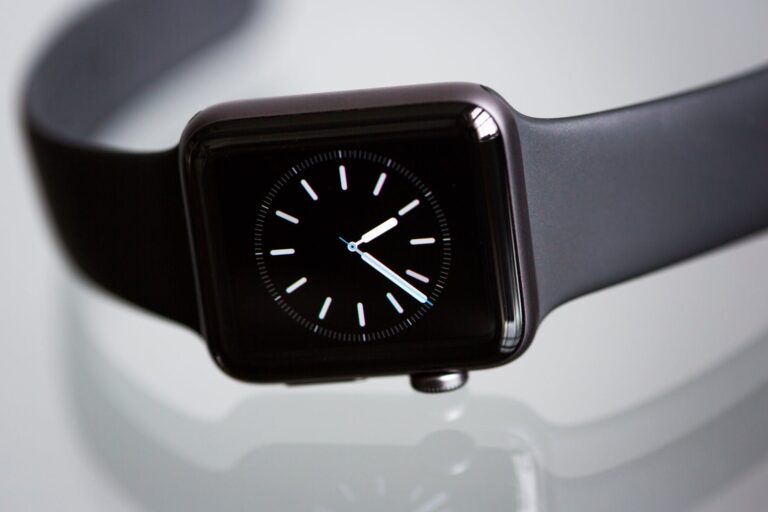 Close-up view of a smartwatch with a black dial and white hands indicating the time