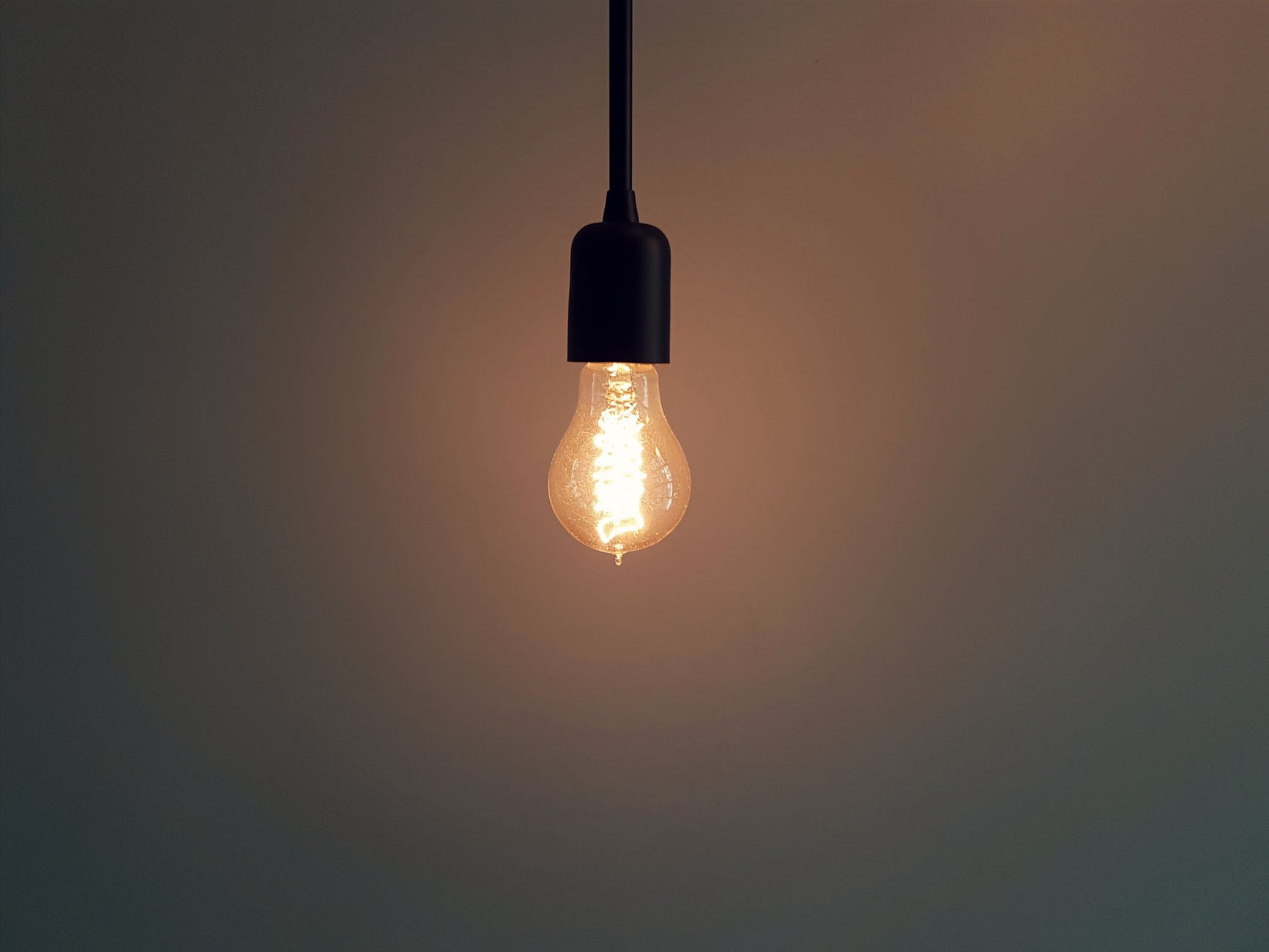 Glowing light bulb in a dark room