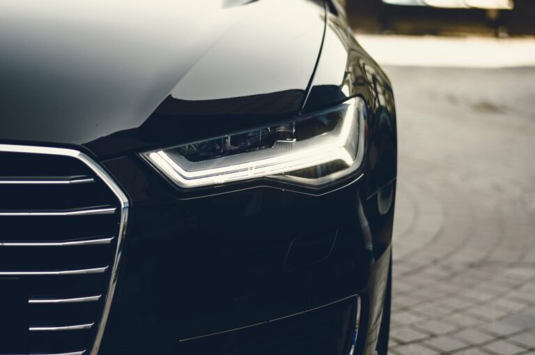 Close-up view of the front headlight and grille of a sleek, black luxury car