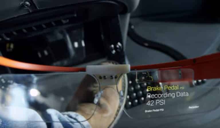 Close-up of a car's brake pedal with a digital display showing recording data and pressure readings