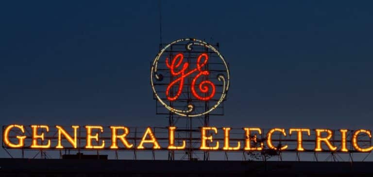 Illuminated General Electric sign at night against a dark blue sky