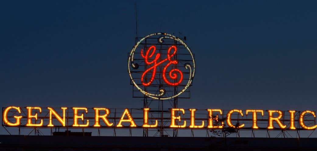 Illuminated General Electric sign at night against a dark blue sky