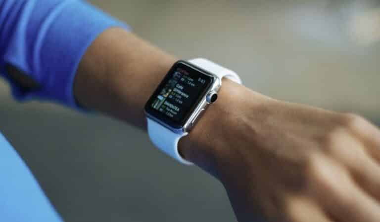 A person's hand wearing a smartwatch with a display showing information