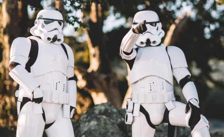 Two Imperial Stormtroopers from Star Wars standing in a forest setting, dressed in their distinctive white armor and helmets.