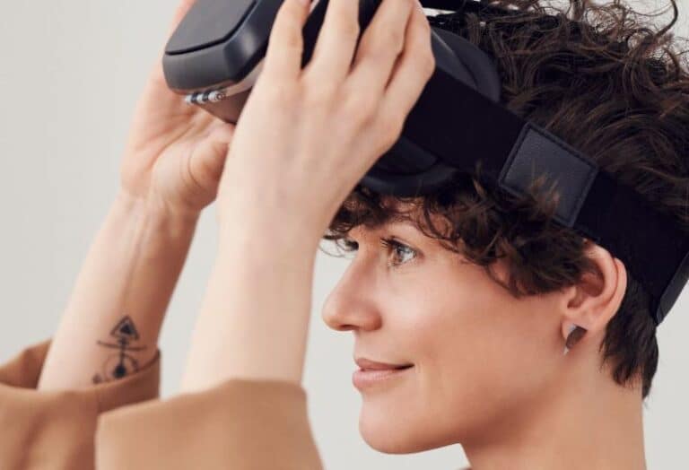 Close-up of a person with short dark hair, wearing a virtual reality headset and looking off to the side.