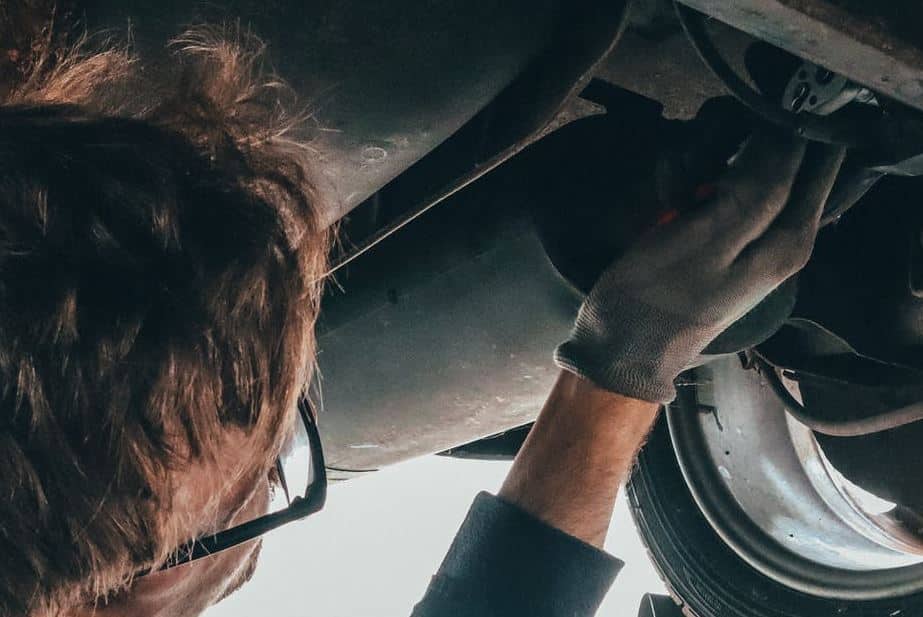 Mechanic working under a car, performing repair or maintenance