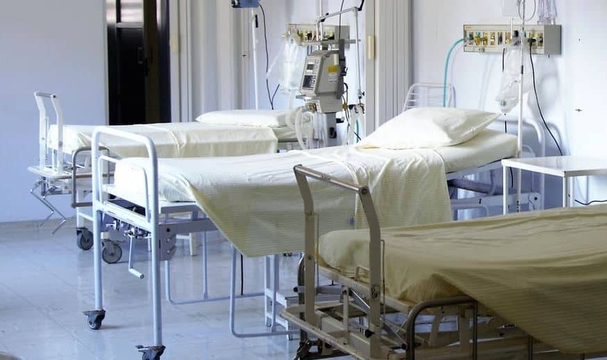 Hospital room with medical equipment, beds, and IV stands