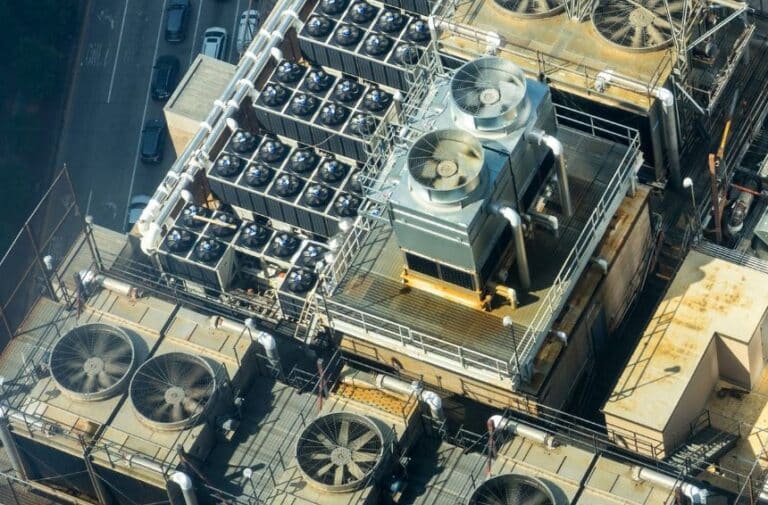 Industrial HVAC equipment and cooling fans on a commercial building rooftop