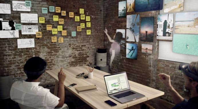 Creative office space with brick walls, laptop, desk, and art on display