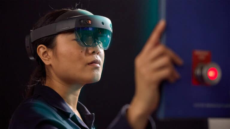 Person wearing a virtual reality headset, gesturing in a dark room