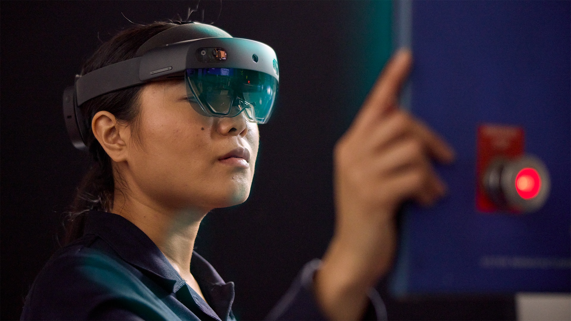 Person wearing a virtual reality headset, gesturing in a dark room