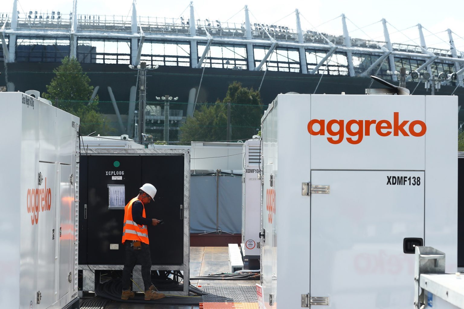 A construction site with modular units and equipment, including an Aggreko-branded container