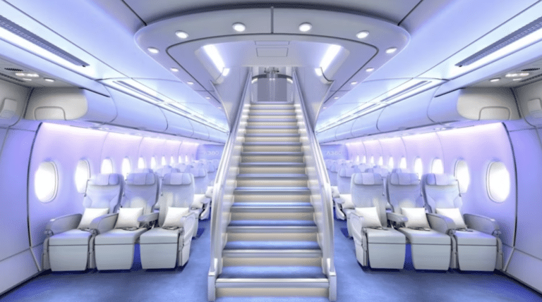 Interior of a modern aircraft cabin with comfortable passenger seats, overhead compartments, and a central stairway leading upwards to the upper deck