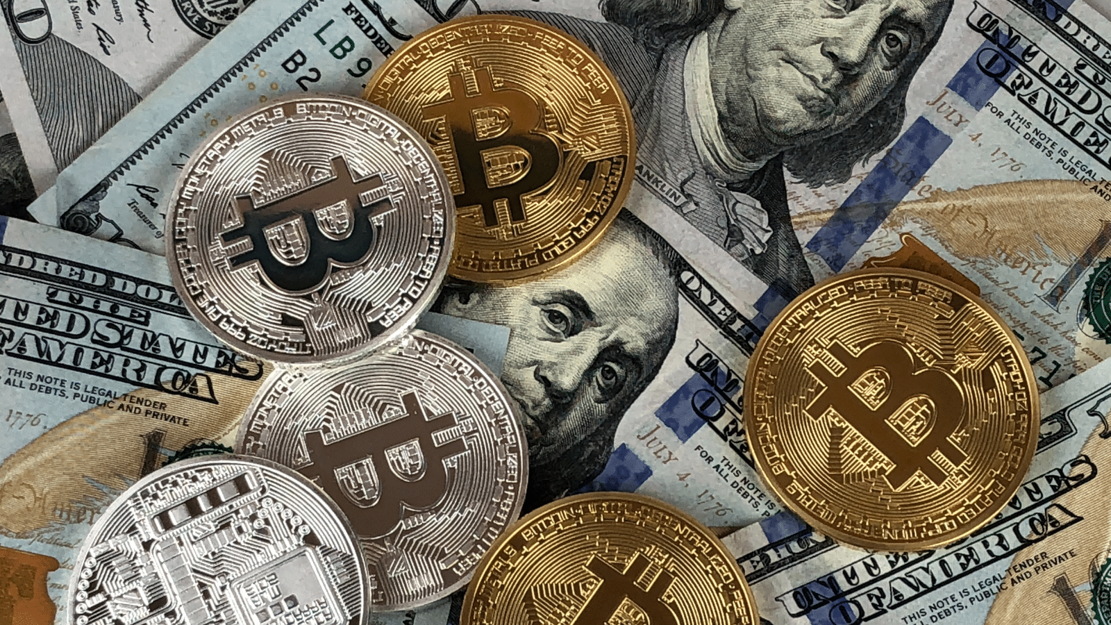 Closeup of gold and silver Bitcoin cryptocurrency coins on US dollar bills