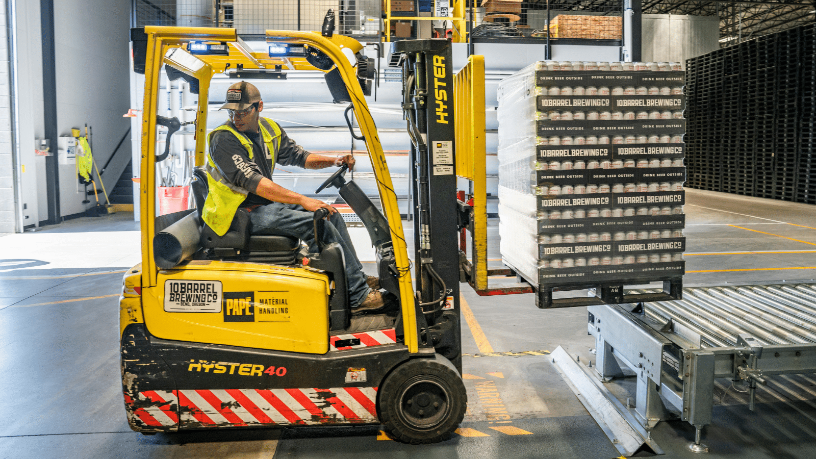 Forklift operator moving boxes of beer products in a warehouse of 10 Barrel Brewing Company
