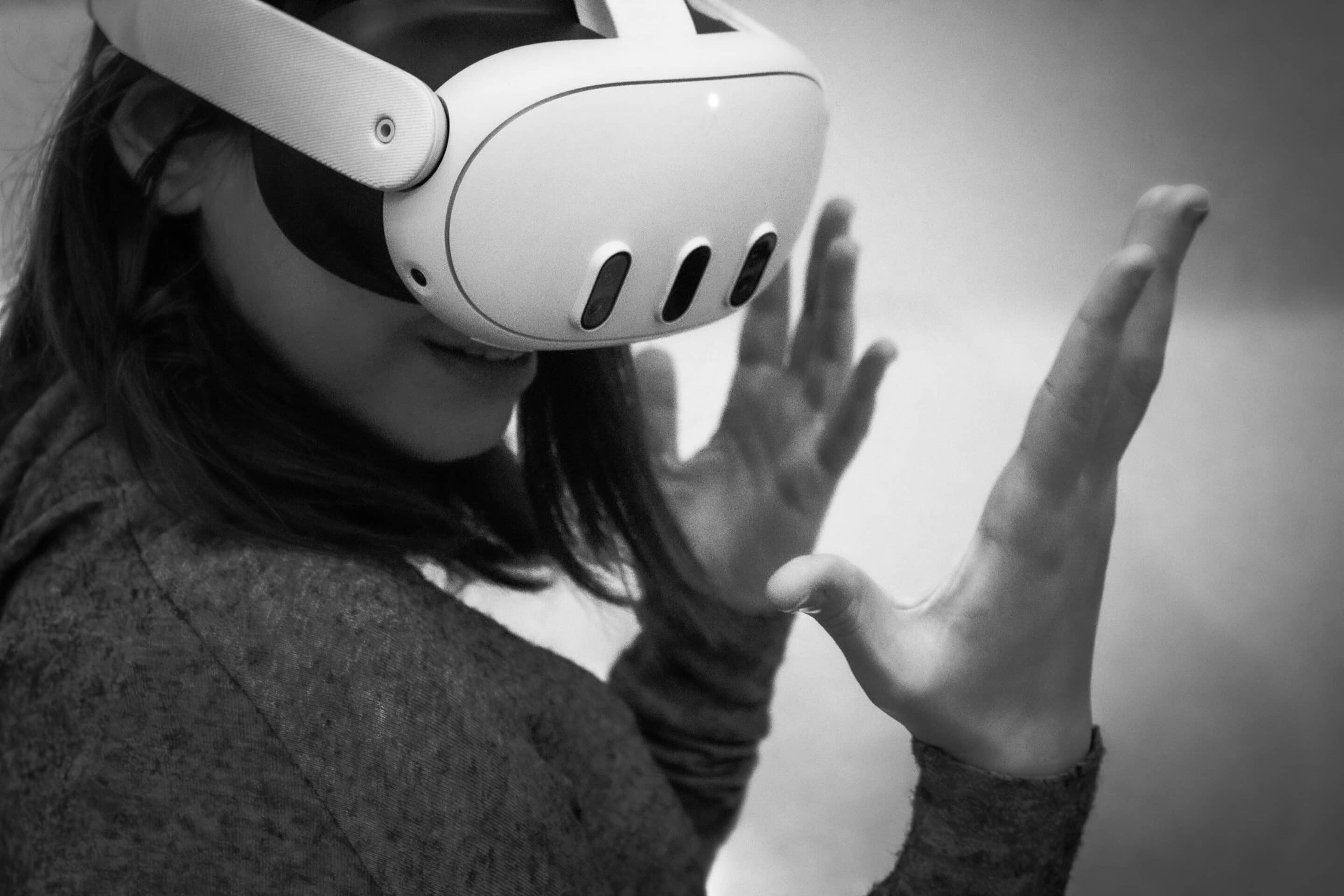 Person wearing virtual reality headset, reaching out with hands in a gesture