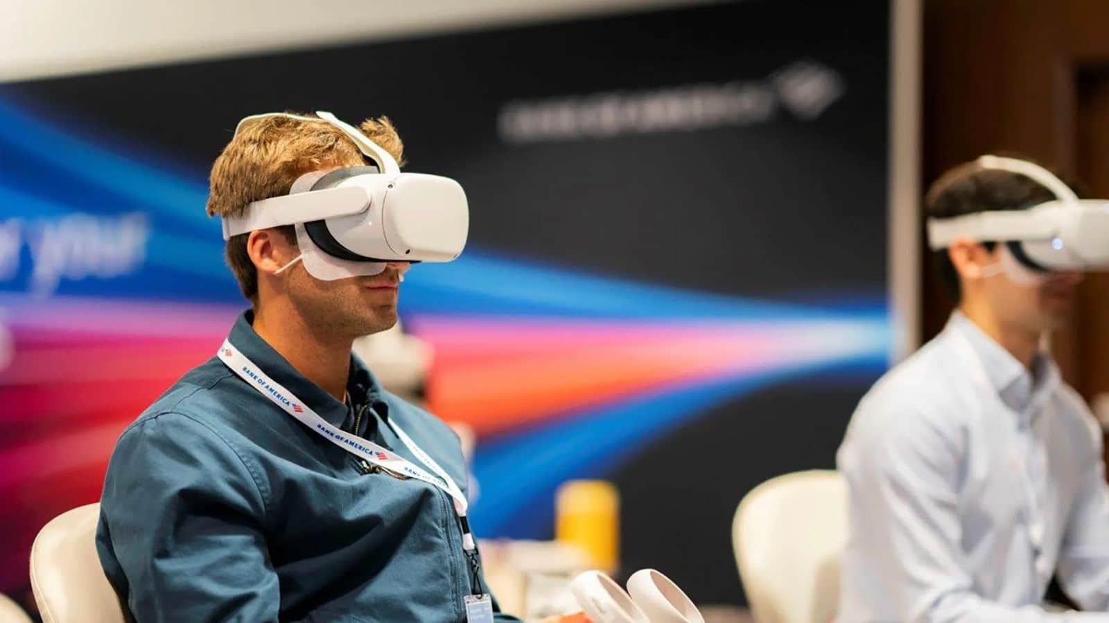 Two individuals wearing virtual reality headsets, immersed in an immersive digital experience at a technology conference.
